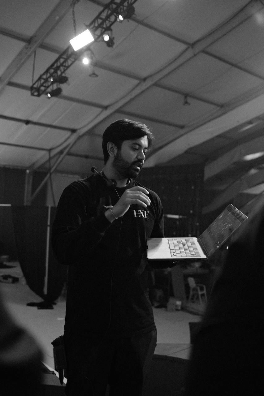 Shailin holding a laptop while speaking at a community gathering